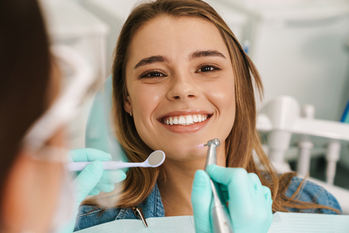 Woman sitting in dental office chair smiling